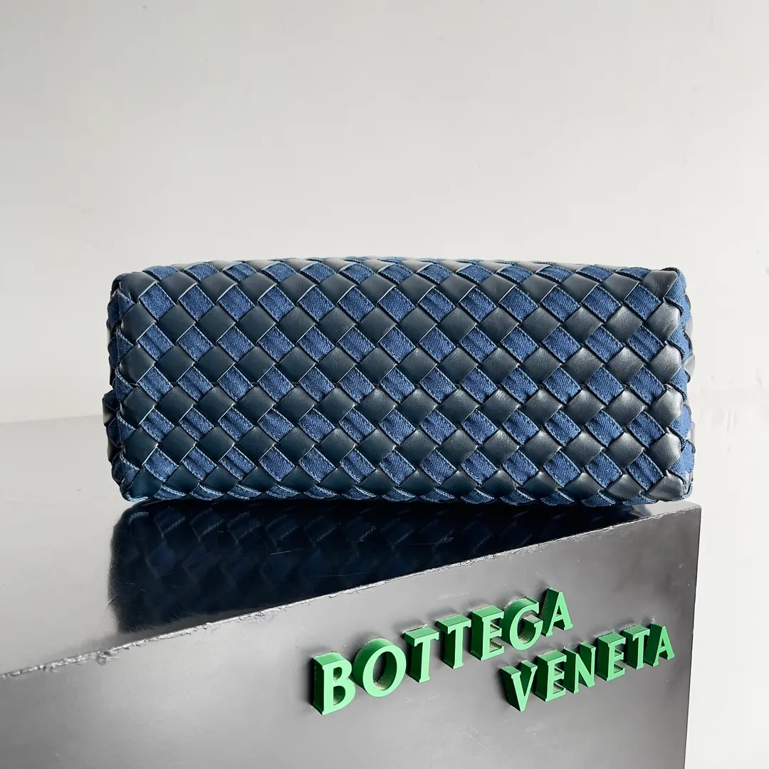 Batch 2260 BOTTEGA VENETA's new ANDIAMO handbag. This denim woven bag perfectly interweaves retro and trendy! Each strand of hand-woven denim carries ingenuity, and the color-blocking design breaks away from the norm. Not only is the capacity impressive, it also adds fun and cuteness, making it easy to hold various styles. Exquisite metal accessories shine on the ruggedness of denim, coexisting toughness and femininity. Denim has its own youthful and energetic attributes, giving people a retro, classic and relaxed and free feeling. During the weaving process of this bag, the denim is hand-woven into the leather through small gaps. The skills are quite exquisite! Not to mention the capacity, it can accommodate an umbrella and a water cup! Style number: 743572 Size: 32*24*12cm